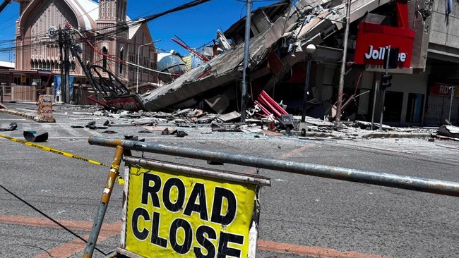 A road closure signage is placed near a collapsed building after a magnitude 7.8 quake in General Santos, Philippines, June 8, 2026. Picture taken with a mobile phone. REUTERS/Edwin Espejo