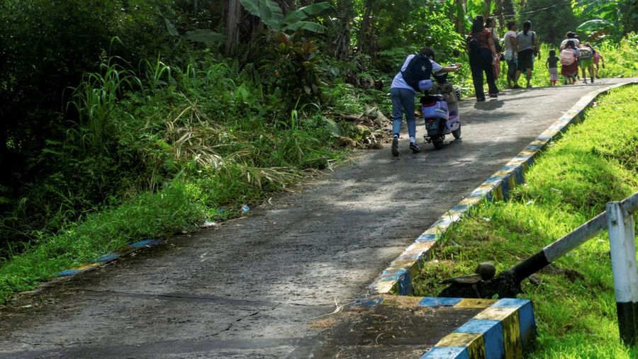 Orang-orang melangkah kaki saat mengungsi ke dataran tinggi setelah badan geofisika Indonesia mengeluarkan peringatan tsunami menyusul gempa bumi di lepas pantai selatan pulau Mindanao, Filipina, nan juga dirasakan di Tahuna, Kabupaten Kepulauan Sangihe, Provinsi Sulawesi Utara, Senin (8/6/2026). (REUTERS/Stenly Pontolawokang)