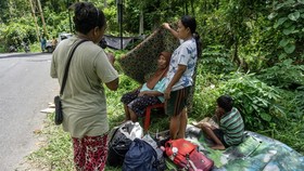 Residents evacuate to higher ground following a tsunami warning issued after a magnitude 7.8 earthquake off the southern Philippines, at Peta Timur village in Sangihe Islands Regency, Indonesia's North Sulawesi province on June 8, 2026. The quake whi