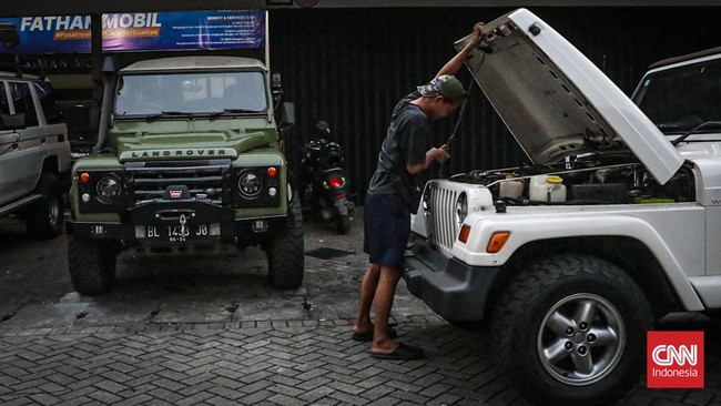 Seorang pekerja diler mengecek mobil yang dijualnya di diler mobil SUV bekas, Sunter, Jakarta, Senin (8/6). (CNN Indonesia/Febria Adha L)