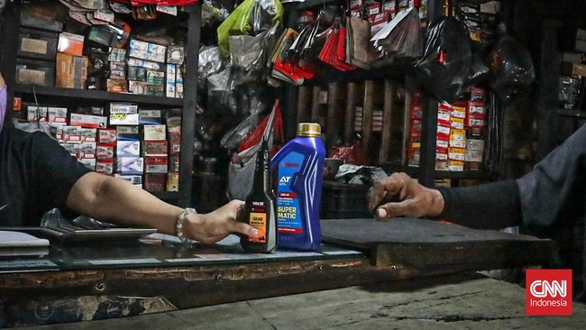 Seorang pedagang menjual berbagai onderdil di bengkel sepeda motor di Cengkareng, Jakarta, Senin (8/6). (CNN Indonesia/Febria Adha L).