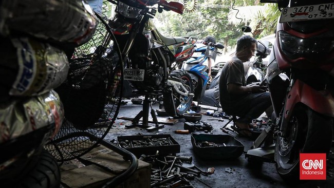 Seorang pedagang menjual berbagai onderdil di bengkel sepeda motor di Cengkareng, Jakarta, Senin (8/6). (CNN Indonesia/Febria Adha L).