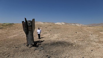 An Israeli ultra-Orthodox Jewish stands near a part of a missile protruding from the ground, following strikes from Iran, in the central Israeli-occupied West Bank, June 8, 2026. REUTERS/Ammar Awad