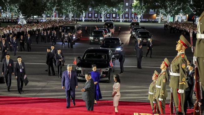 Chinese President Xi Jinping, his wife Peng Liyuan, North Korean leader Kim Jong Un, and his wife Ri Sol Ju together on a red carpet as they attend a performance at the Pyongyang Indoor Stadium, during Xi's state visit, in Pyongyang, North Korea, Jun