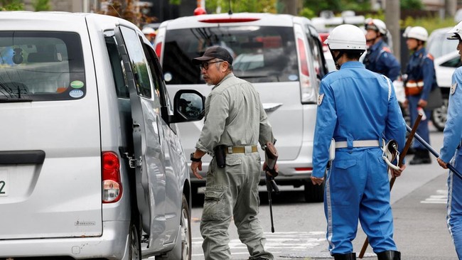 A zoo staff member and police officers with sticks search for a black bear that was spotted at a residential area in Utsunomiya, Tochigi Prefecture, Japan, June 9, 2026. REUTERS/Kim Kyung-Hoon