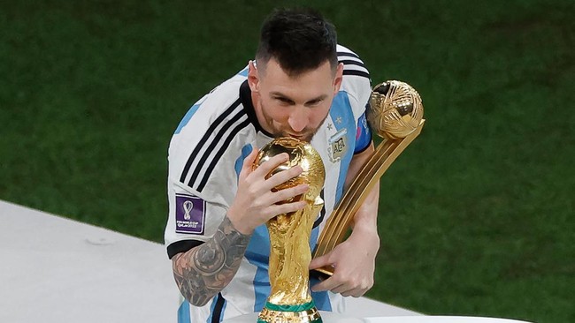 Argentina's forward #10 Lionel Messi kisses the World Cup trophy after receiving the Golden Ball award during the Qatar 2022 World Cup trophy ceremony after the football final match between Argentina and France at Lusail Stadium in Lusail, north of D