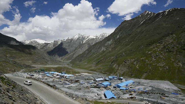 A vehicle rides past a construction site near the Zojila tunnel, India's longest road tunnel project connecting Jammu and Kashmir with the Ladakh region, in Minamarg on June 9, 2026. Indian engineers broke through the final rock section in the strate