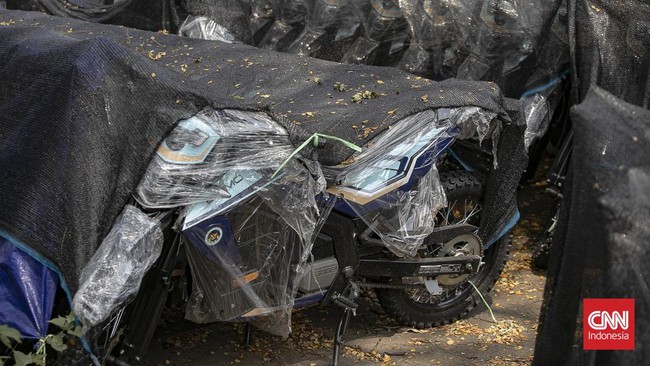 Deretan motor listrik berwarna biru-hitam terlihat terparkir rapi di kawasan industri Sentul, Kabupaten Bogor, Rabu (10/6/2026). Kendaraan-kendaraan tersebut berjajar di area terbuka dan tertutup jaring terpal berwarna hitam yang mulai dipenuhi daun-