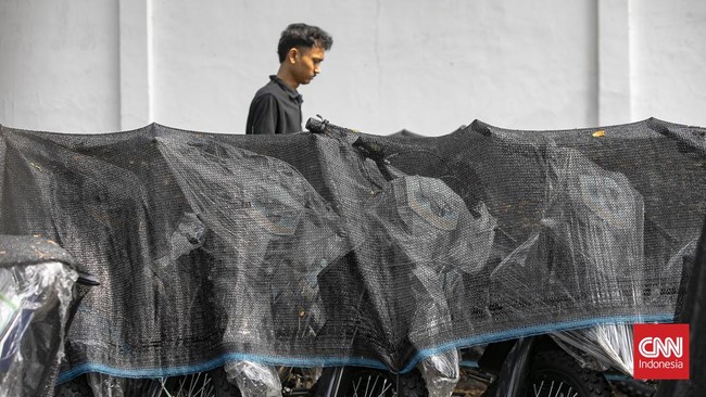 Deretan motor listrik berwarna biru-hitam terlihat terparkir rapi di kawasan industri Sentul, Kabupaten Bogor, Rabu (10/6/2026). Kendaraan-kendaraan tersebut berjajar di area terbuka dan tertutup jaring terpal berwarna hitam yang mulai dipenuhi daun-