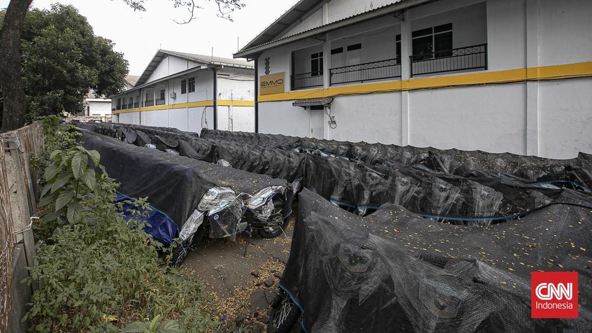 Deretan motor listrik berwarna biru-hitam terlihat terparkir rapi di kawasan industri Sentul, Kabupaten Bogor, Rabu (10/6/2026). Kendaraan-kendaraan tersebut berjajar di area terbuka dan tertutup jaring terpal berwarna hitam yang mulai dipenuhi daun-