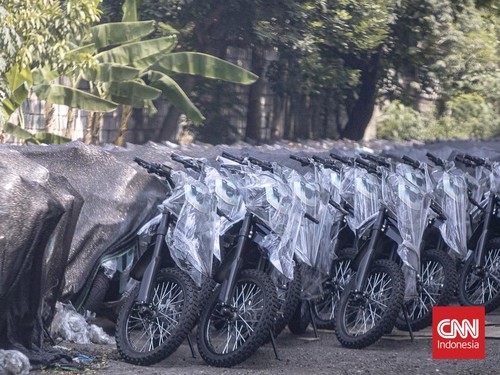 Deretan motor listrik berwarna biru-hitam terlihat terparkir rapi di kawasan industri Sentul, Kabupaten Bogor, Rabu (10/6/2026). Kendaraan-kendaraan tersebut berjajar di area terbuka dan tertutup jaring terpal berwarna hitam yang mulai dipenuhi daun-