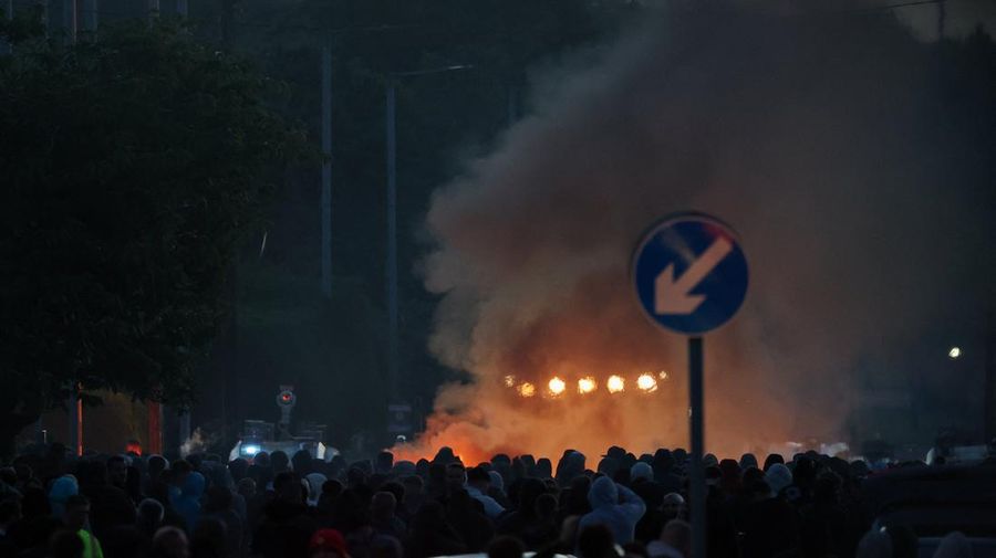 Asap mengepul saat para demonstran anti-imigran berunjuk rasa, menyusul serangan pisau pada 8 Juni nan menyebabkan seorang laki-laki terluka parah dan mendorong polisi untuk menyatakan kejadian tersebut sebagai kejadian kritis, di Belfast, Irlandia Utara, 10 Juni 2026.