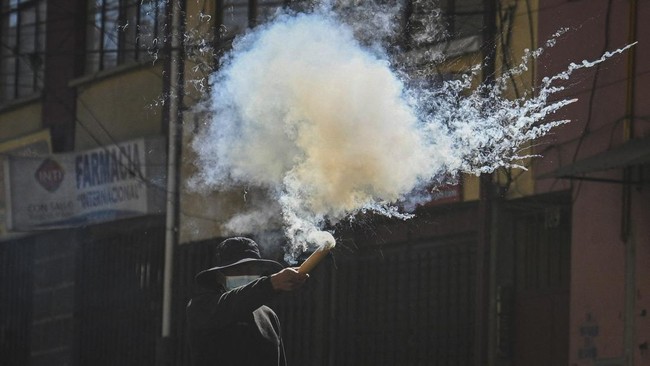 A demonstrator throws a smoking projectile during a protest calling for the resignation of Bolivia's President Rodrigo Paz, following weeks of protests and blockades that have caused shortages of food, fuel and medicine, in La Paz, Bolivia, June 10,
