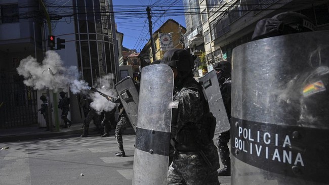 Police officers fire tear gas while clashing with demonstrators during a protest calling for the resignation of Bolivia's President Rodrigo Paz, following weeks of protests and blockades that have caused shortages of food, fuel and medicine, in La Pa