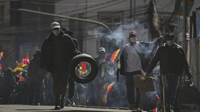 Demonstrators carry tires and cardboard to build bonfires during a protest calling for the resignation of Bolivia's President Rodrigo Paz, following weeks of protests and blockades that have caused shortages of food, fuel and medicine, in La Paz, Bol