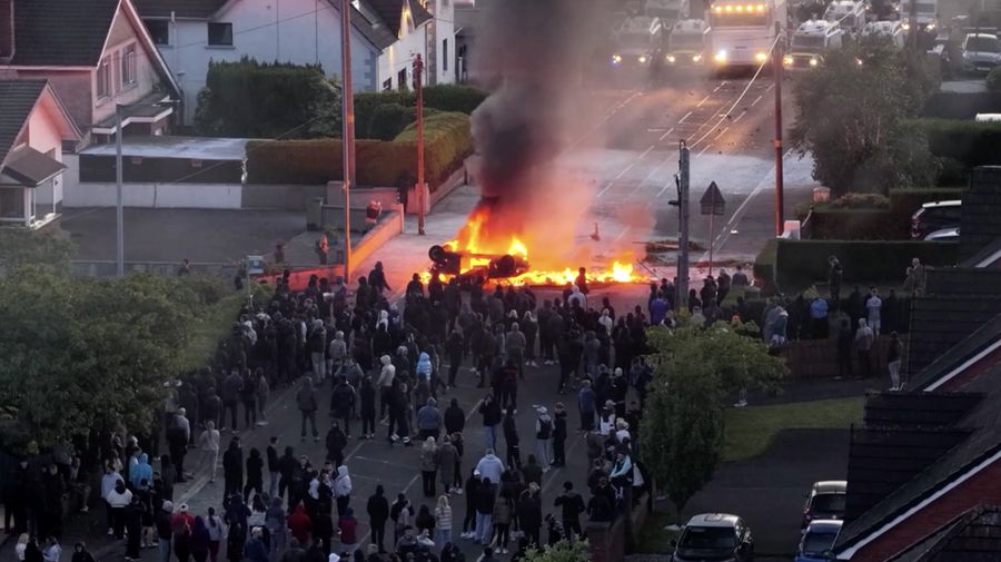 Sebuah kendaraan dibakar saat polisi memblokir sejumlah jalan di Belfast pada malam kedua kerusuhan bernuansa anti-imigran nan memicu ketegangan di wilayah tersebut. (Tangkapan Layar Video Reuters/)