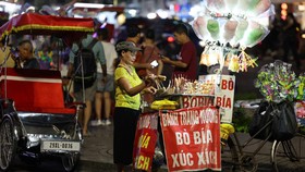 A street vendor waits for customers in Hanoi on may 23, 2025. (Photo by Ludovic MARIN / AFP)