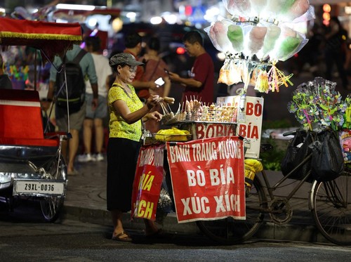 A street vendor waits for customers in Hanoi on may 23, 2025. (Photo by Ludovic MARIN / AFP)