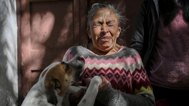 Volunteer Claudia Gutierrez of the Adopta Amor pet shelter plays with a dog at the shelter as roadblocks around La Paz and El Alto disrupt food supplies, leaving the shelter struggling to care for 48 dogs and other animals and relying on sporadic don