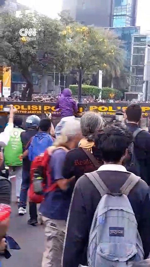 Massa aksi demonstrasi mencoba menerobos barikade polisi di sekitar Dukuh Atas, Jakarta Pusat pada Jumat (12/6).
