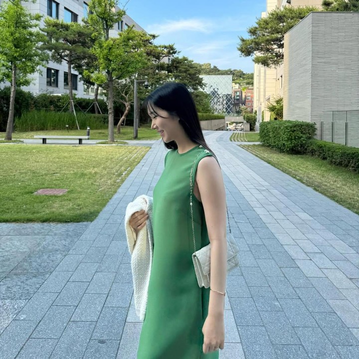 <p>Di lain kesempatan, ia juga mengenakan dress tanpa lengan namun dengan warna yang lebih berani. Seperti tampak dalam foto, Yoo Kyung tengah berjalan-jalan di taman dengan dress hijau dipadu tas dan outer putih. Foto: Instagram @Yukyung_922</p>