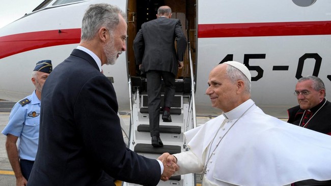 Spain's King Felipe shakes hands with Pope Leo XIV as the Pope prepares to board a Falcon 900B Spanish Air Force plane that was offered by the King after the aircraft the Pope was due to depart with had a technical issue, according to local media, at