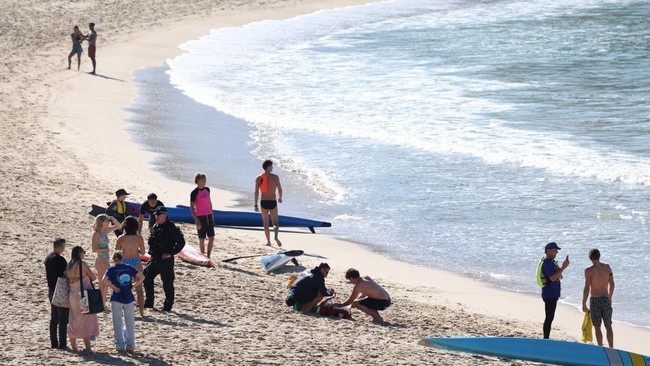 A police officer speaks to people following a shark attack at Coogee Beach in Sydney, Australia, June 13, 2026. REUTERS/Hollie Adams