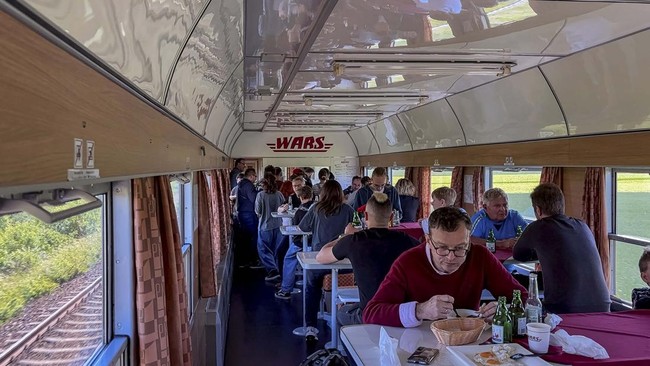 Passengers crowd a busy dining car aboard the