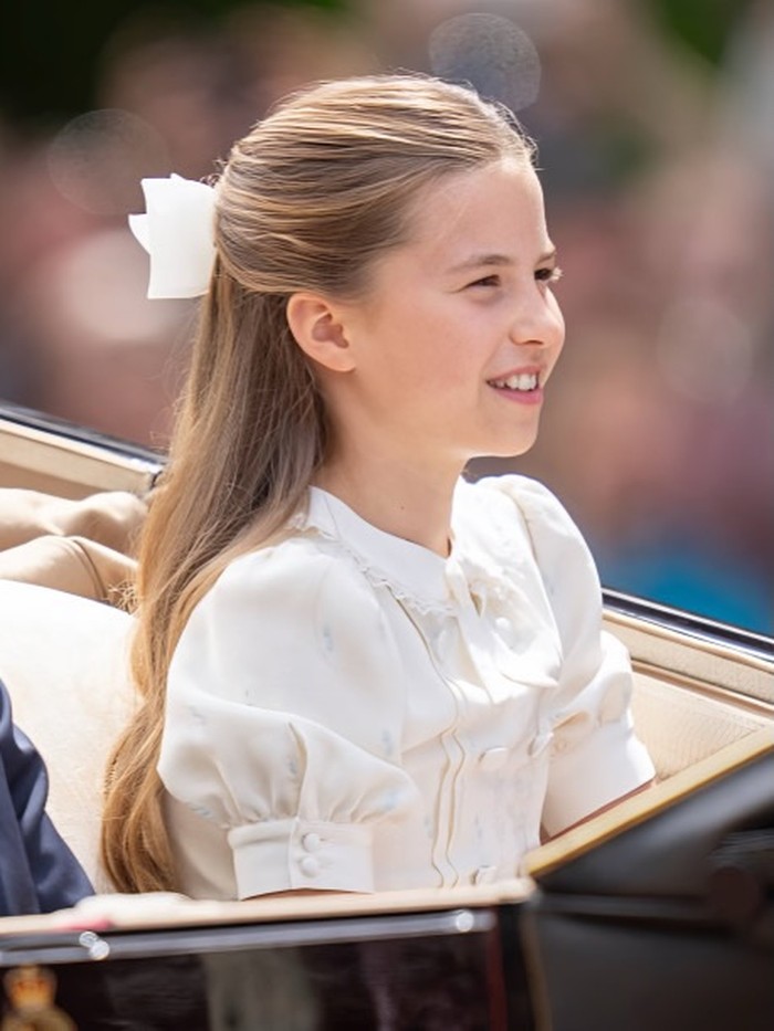 Putri Charlotte tampil manis dengan dress&nbsp;putih berlengan puff dan detail pita putih pada kerah. Rambutnya ditata half-up dengan pita besar/Foto: instagram.com/walesroyalfans