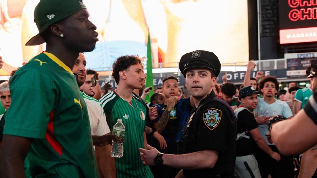 Soccer Football - FIFA World Cup 2026 - Argentina Fans gather in Times Square, New York - New York, New York, U.S. - June 15, 2026 A New York police officer intervenes as Algeria fans clash with Argentina fans in Times Square REUTERS/Carolina Herrera