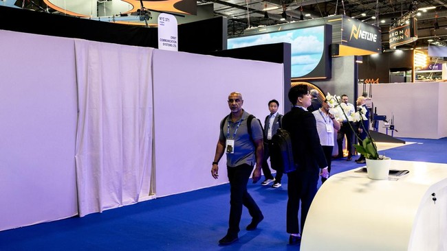 Visitors walk by the closed stand of Israeli airborne and maritime communications, satellite tracking, and ground-station technology company Orbit Communication Systems at the Eurosatory land and airland defence and security trade fair, at the Paris-