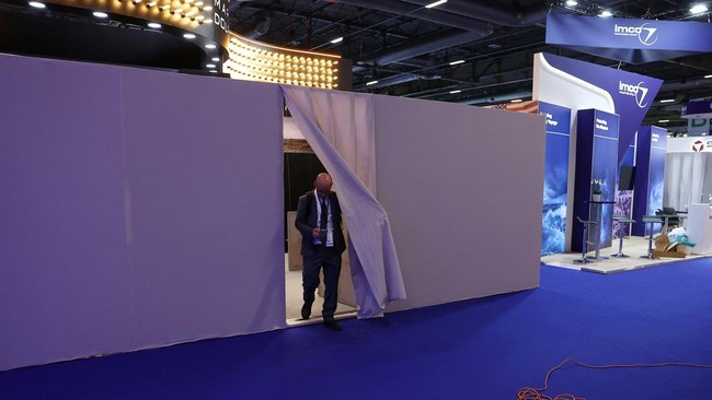 A man leaves the walled off booth of the Israeli company Marom Dolphin at the Eurosatory international land and air defence and security trade fair in Villepinte near Paris, France, June 15, 2026. REUTERS/Alice Sacco