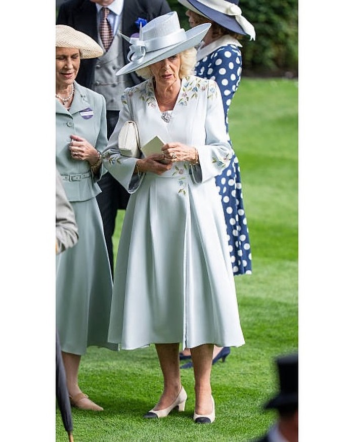 Ratu Camilla tampil anggun dalam coat dress biru muda rancangan Anna Valentine dengan detail bordir bunga, dipadukan topi Philip Treacy dan sepatu Chanel/Foto: instagram.com/royalfashionpolice