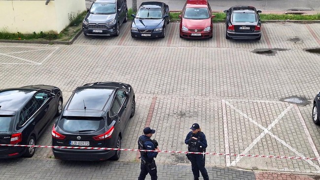 This general view taken on June 16, 2026 shows an area cordoned off by police around a crime scene covered with a tent (back C) near a car park in Biala Podlaska, eastern Poland, where Russian artist Semyon Skrepetsky, known for his satirising Russia