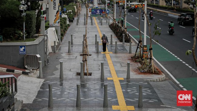 Sejumlah pekerja memugarkan area pedestrian Rasuna Said dalam rangka menyambut HUT DKI Jakarta ke-499 di Kuningan, Jakarta, Rabu (17/6). (CNN Indonesia/Febria Adha L)