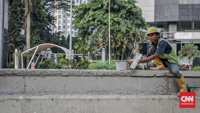 Sejumlah pekerja memugarkan area pedestrian Rasuna Said dalam rangka menyambut HUT DKI Jakarta ke-499 di Kuningan, Jakarta, Rabu (17/6). (CNN Indonesia/Febria Adha L)