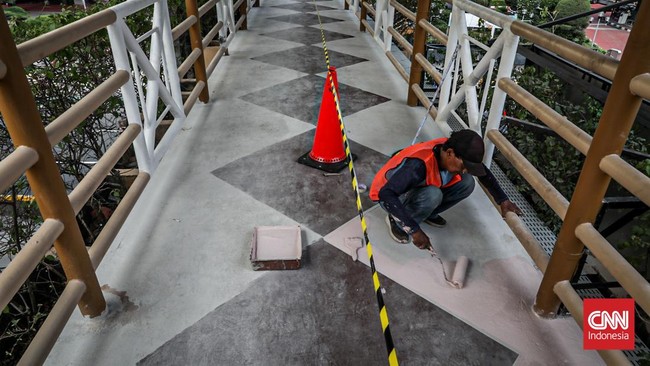 Sejumlah pekerja memugarkan area pedestrian Rasuna Said dalam rangka menyambut HUT DKI Jakarta ke-499 di Kuningan, Jakarta, Rabu (17/6). (CNN Indonesia/Febria Adha L)