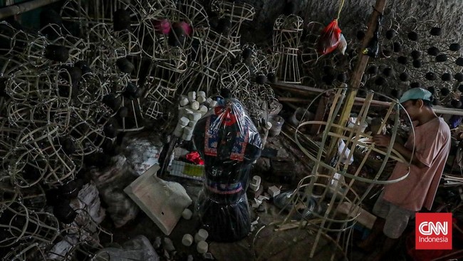 Seorang pekerja merakit kerangka ondel-ondel di rumah produksi ASNR Kampung Betawi, Jagakarsa, Jakarta, Kamis (18/6). (CNN Indonesia/Febria Adha L)