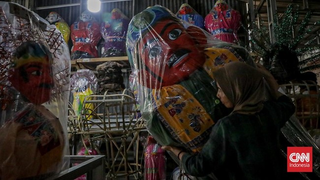 Seorang pekerja merakit kerangka ondel-ondel di rumah produksi ASNR Kampung Betawi, Jagakarsa, Jakarta, Kamis (18/6). (CNN Indonesia/Febria Adha L)