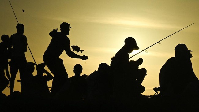 People fish at sunset along the Malecon in Havana on June 17, 2026. (Photo by YAMIL LAGE / AFP)