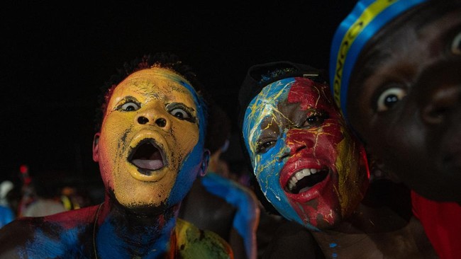 Congolese supporters dressed in the colors of the Democratic Republic of Congo's national flag celebrate the Leopards' equalizing goal in a street in Bunia at night during a FIFA World Cup match between DR Congo and Portugal in Bunia, Ituri Province,