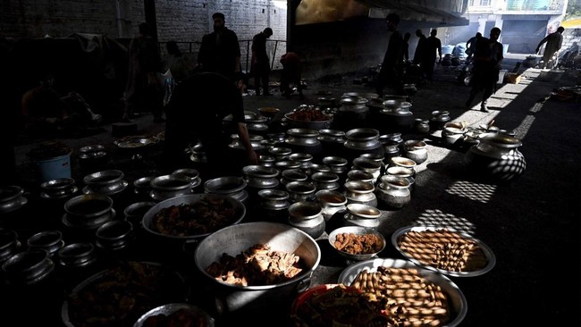 This photograph taken on June 3, 2026 shows Kashmiri chefs or 'wazas' cooking a traditional local feast known as 'wazwan' for wedding guests in Srinagar. Every Kashmiri wedding has its own story, but all share a common thread of the 'wazwan', a famed