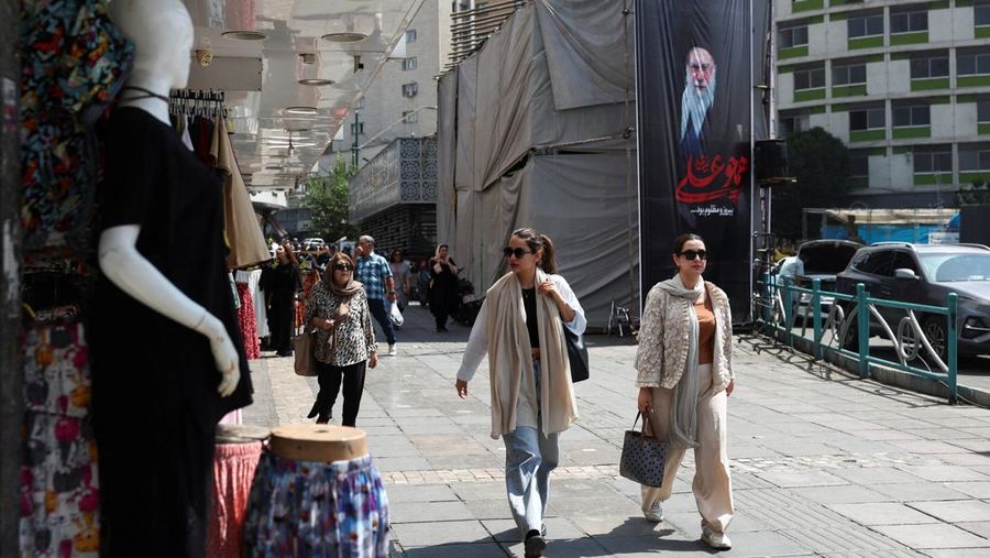 Orang-orang melangkah melewati spanduk dengan gambar mendiang Pemimpin Tertinggi Iran Ayatollah Ali Khamenei, di Teheran, Iran, 17 Juni 2026. (via REUTERS/Majid Asgaripour)
