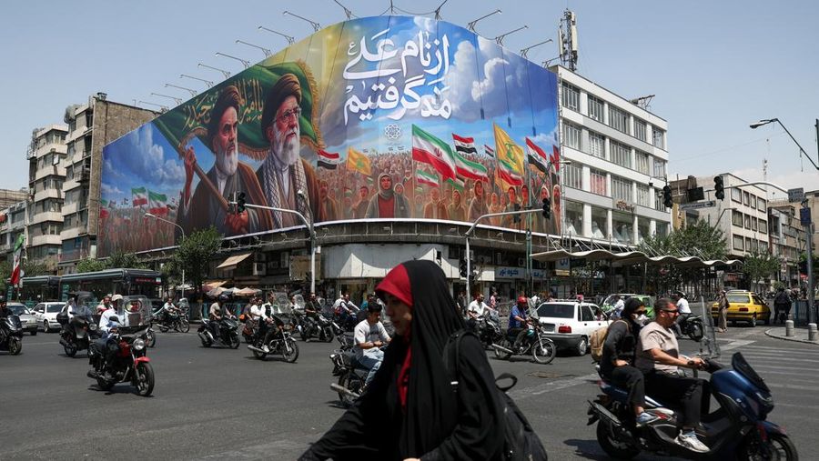 Orang-orang melewati papan iklan nan menggambarkan mendiang pemimpin Revolusi Islam, Ayatollah Ruhollah Khomeini, dan mendiang Pemimpin Tertinggi Iran, Ayatollah Ali Khamenei, di sebuah jalan di Teheran, Iran, (6/6/2026).  (via REUTERS/Majid Asgar