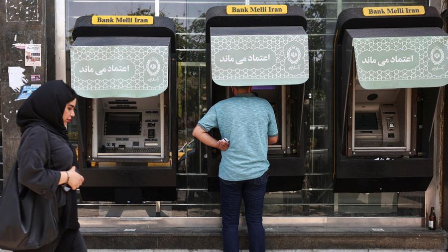 Seorang laki-laki menggunakan ATM Bank Melli Iran di depan sebuah bank di Teheran, Iran, 17 Juni 2026. (via REUTERS/Majid Asgaripour)