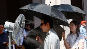 A man stands in front of a cooler spraying water ahead of Thom Browne’s Spring/Summer 2027. REUTERS/Alessandro Garofalo