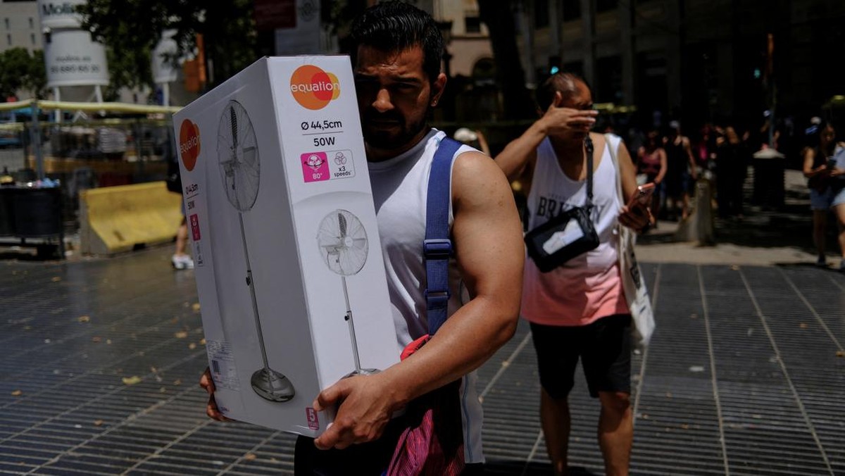 A man carries a newly purchased fan as temperatures rise, during a heatwave affecting a large part of Spain, in Barcelona, in Spain, June 21, 2026. REUTERS/Nacho Doce