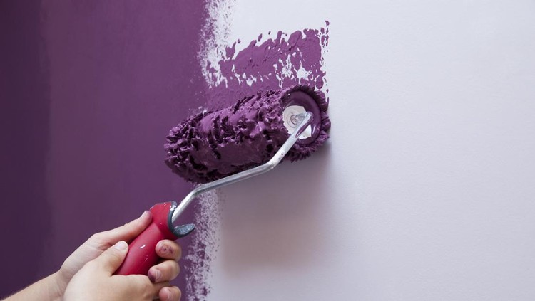 Two hands &lpar;woman&rpar; pinting the wall with a paint roller