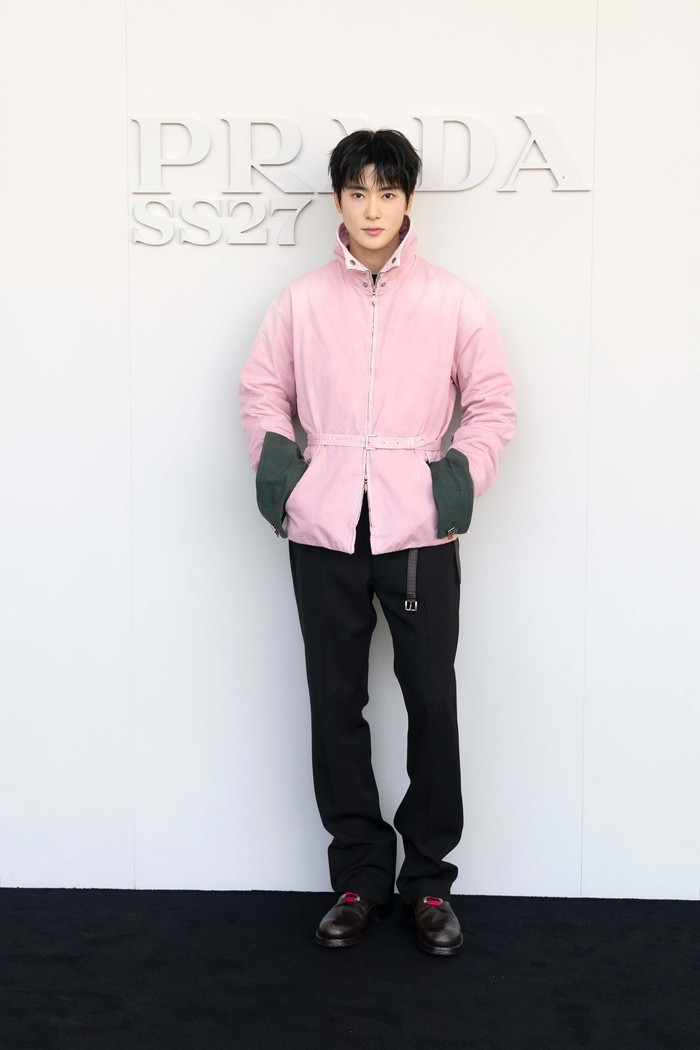 Simple, tapi atraktif. Jaehyun mengenakan jaket pink dengan celana hitan berpotongan lurus. Gaya lebih menarik dengan styling double belt yang tampak sebagai aksen pada jaket serta ikat pinggang hitam dengan buckle yang dibiarkan jatuh/ Foto: Dok. Prada