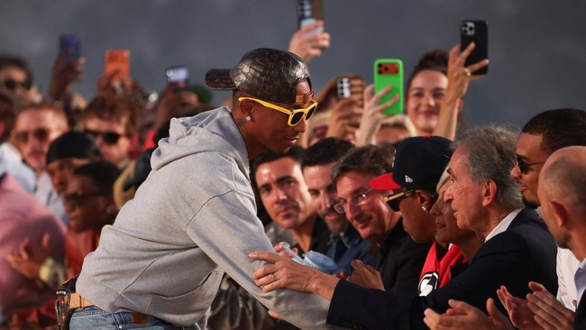 Designer and musician Pharrell Williams greets Bernard Arnault, Chairman and CEO of LVMH at the end of his Menswear Spring-Summer 2027 collection show for fashion house Louis Vuitton during Men's Fashion Week in Paris, France, June 23, 2026. REUTERS/